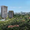 Aerial view of Bloomsbury Residences, a new launch condo in Singapore's one-north area, featuring three modern high-rise towers surrounded by lush greenery, a swimming pool, and a city skyline in the background. Artist's impression.